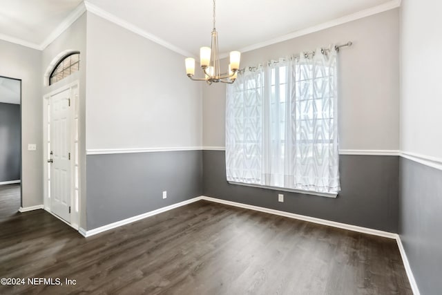 unfurnished dining area with crown molding, an inviting chandelier, wood finished floors, and baseboards