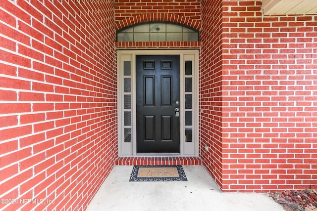 property entrance featuring brick siding