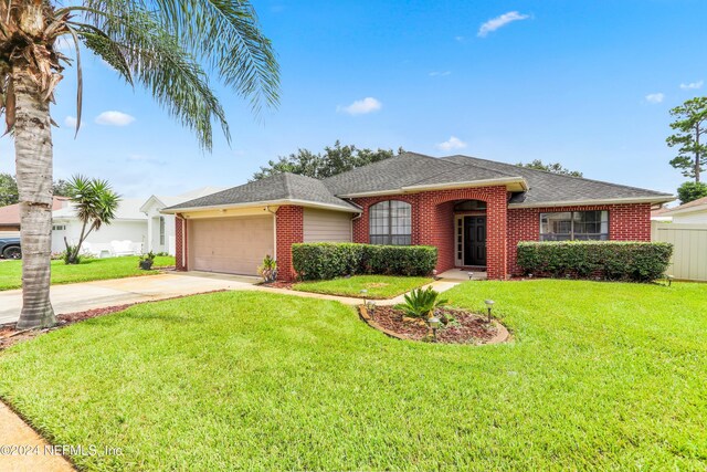 ranch-style house featuring a front yard and a garage