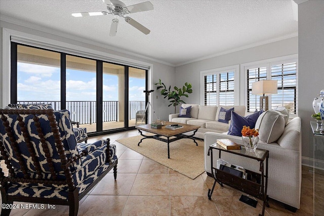 living room with ceiling fan, light tile patterned floors, crown molding, and a textured ceiling