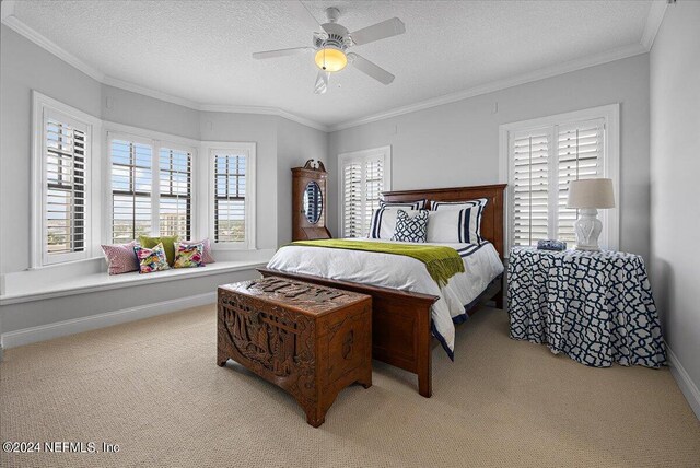 bedroom featuring ceiling fan, light carpet, a textured ceiling, and ornamental molding