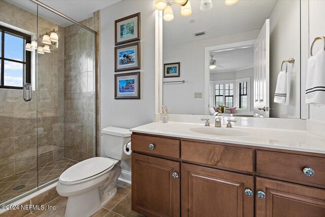 bathroom featuring ceiling fan, toilet, tile patterned flooring, vanity, and a textured ceiling