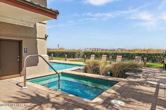 view of pool with a community hot tub and a patio area