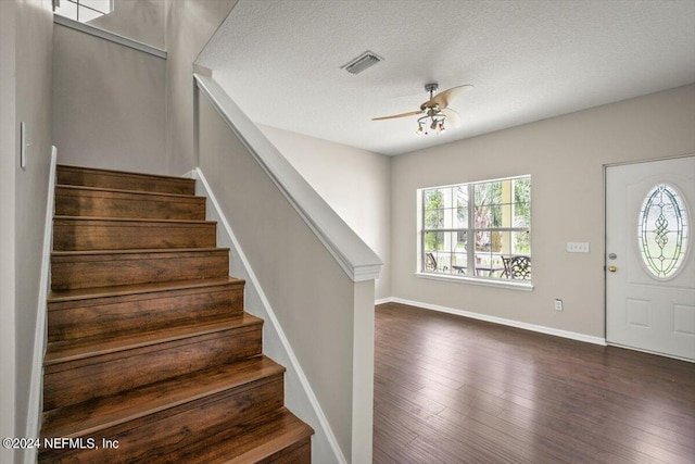 entrance foyer featuring a textured ceiling, dark wood-type flooring, and ceiling fan