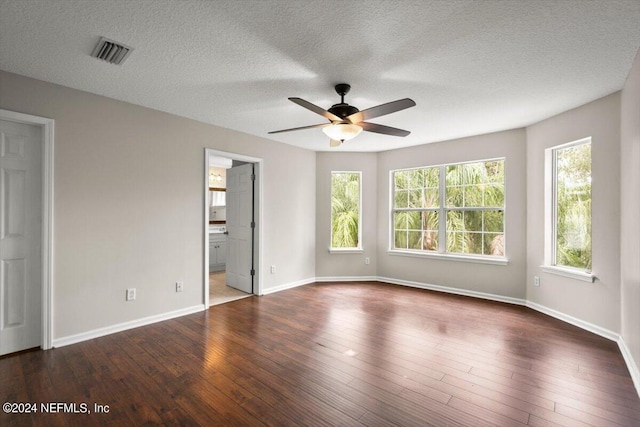 unfurnished room featuring dark wood-type flooring, a textured ceiling, and ceiling fan