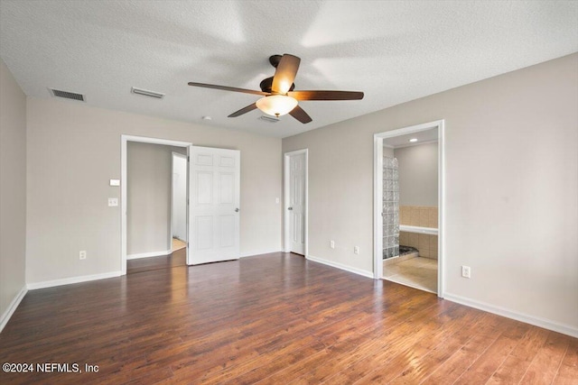 unfurnished bedroom with a textured ceiling, ensuite bath, dark hardwood / wood-style floors, and ceiling fan