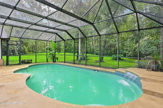 view of swimming pool featuring a patio, pool water feature, a lawn, and a lanai