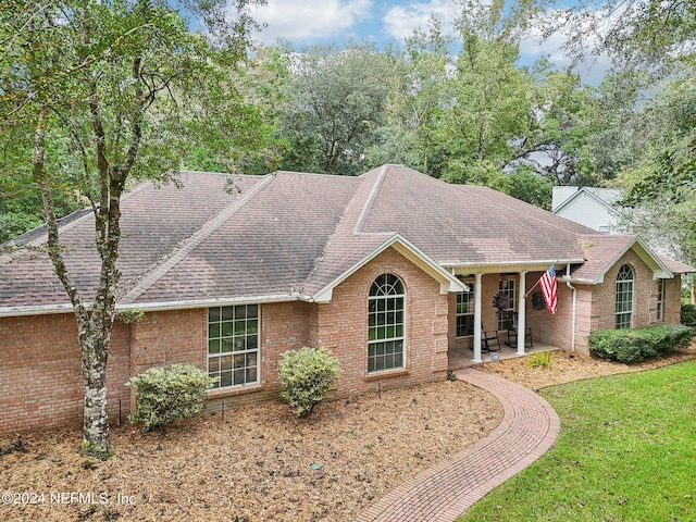 ranch-style house featuring a front lawn and a patio