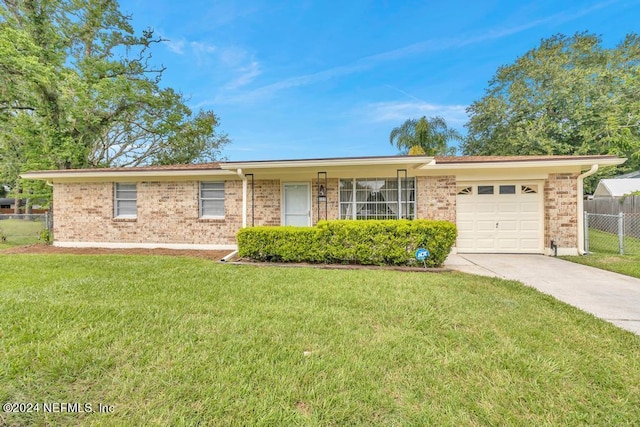 single story home featuring a front yard, concrete driveway, fence, and an attached garage