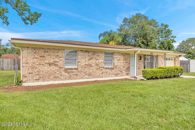 single story home with brick siding, fence, and a front yard