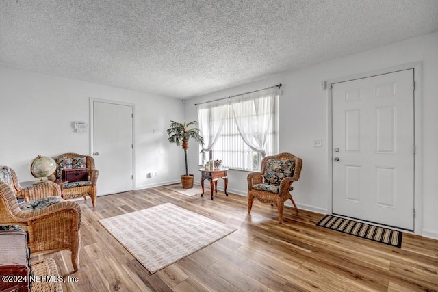 sitting room with light hardwood / wood-style flooring and a textured ceiling