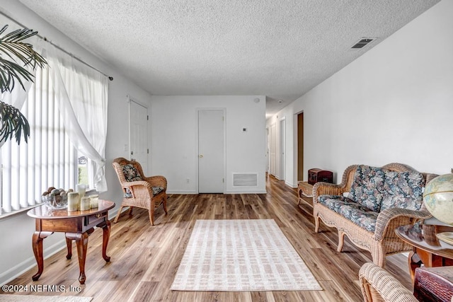 sitting room featuring a textured ceiling and light hardwood / wood-style flooring