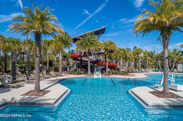 view of pool featuring a water slide and a patio