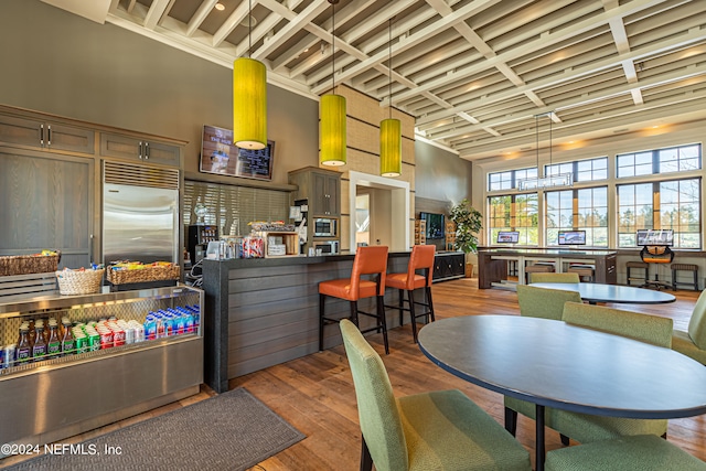 dining room with coffered ceiling, dark hardwood / wood-style floors, and a towering ceiling