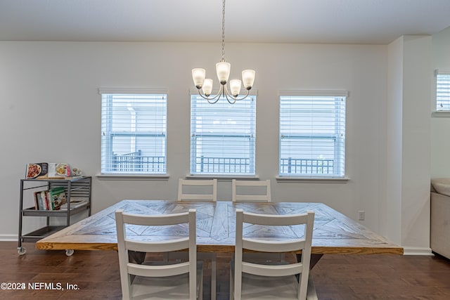 dining area with plenty of natural light, dark wood-type flooring, and a chandelier