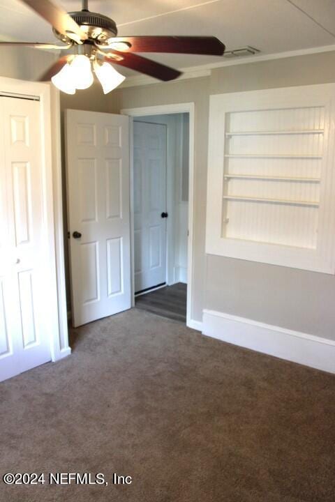 carpeted empty room featuring ceiling fan and ornamental molding