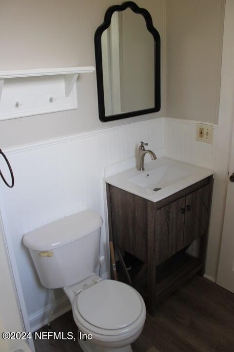 bathroom featuring toilet, vanity, and hardwood / wood-style floors