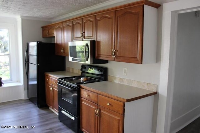 kitchen with a textured ceiling, black appliances, and dark wood-type flooring