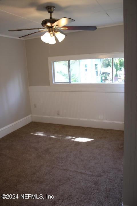 carpeted spare room with ceiling fan