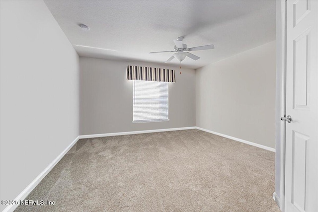 carpeted spare room featuring a textured ceiling and ceiling fan