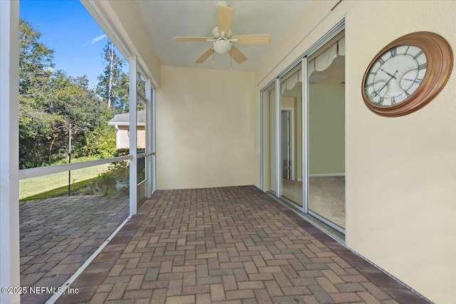 unfurnished sunroom with ceiling fan