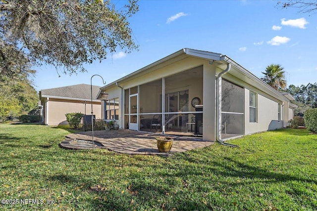 rear view of property with a sunroom, a yard, and a patio