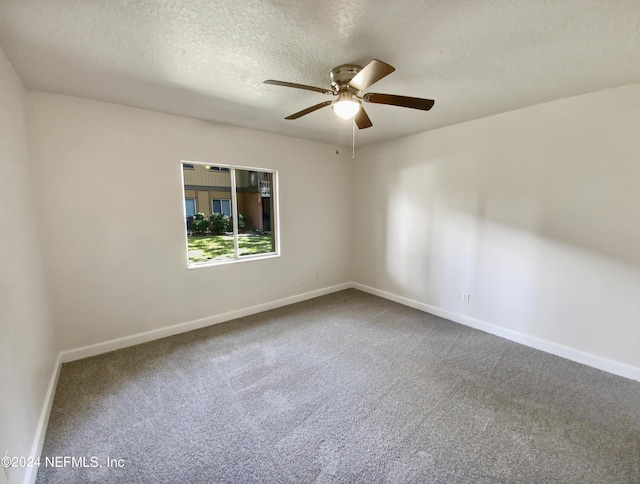 empty room featuring a textured ceiling, carpet flooring, and baseboards