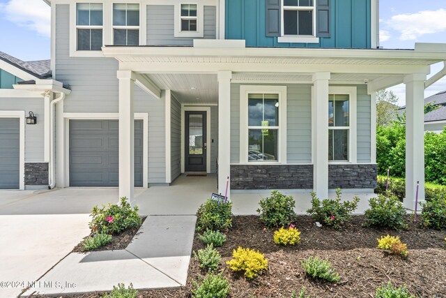 doorway to property featuring a garage and covered porch