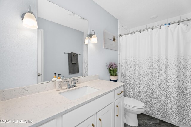 full bath with a shower with shower curtain, vanity, and toilet