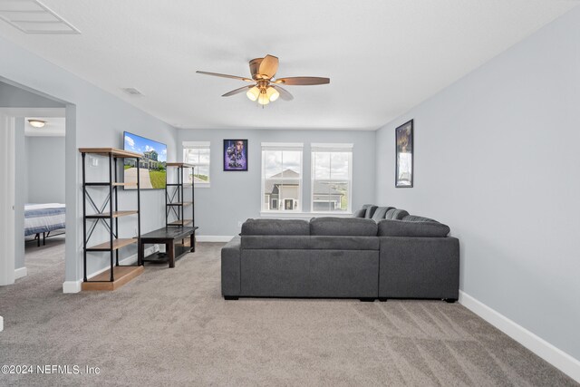 carpeted living room with ceiling fan