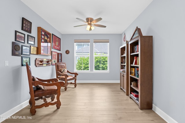 sitting room featuring ceiling fan, baseboards, and wood finished floors