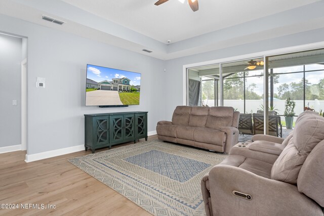 living room featuring light hardwood / wood-style flooring and ceiling fan