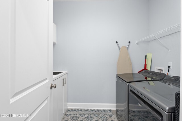 laundry room featuring washing machine and dryer and cabinets