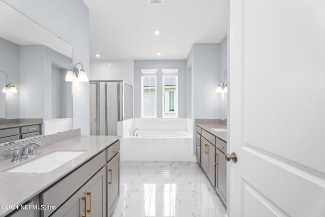 full bathroom featuring marble finish floor, two vanities, a stall shower, a sink, and a bath