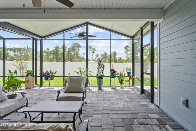 sunroom with a wealth of natural light, ceiling fan, and vaulted ceiling