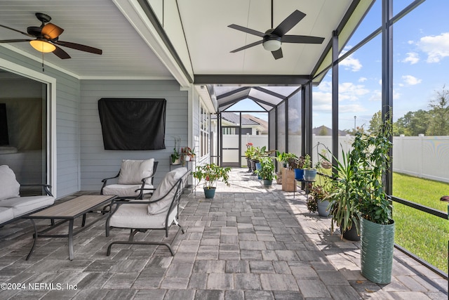 sunroom with ceiling fan and vaulted ceiling