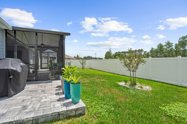 view of yard with a sunroom, a patio area, ceiling fan, and a fenced backyard