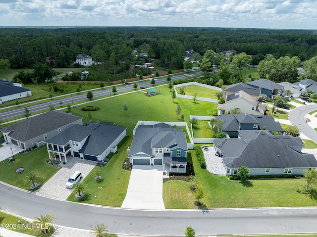 drone / aerial view featuring a residential view and a forest view