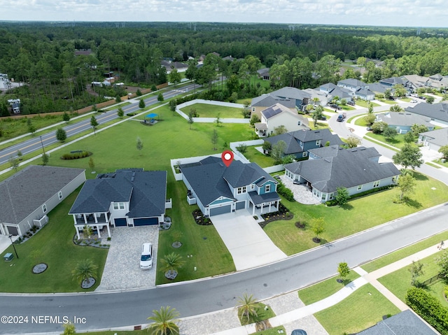 drone / aerial view featuring a residential view and a wooded view