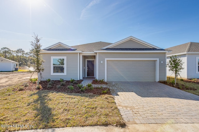 ranch-style home featuring a garage and a front yard