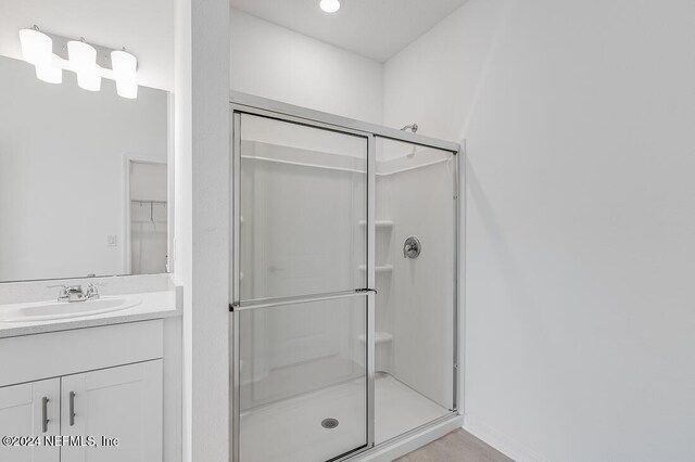 bathroom with vanity and a shower with door