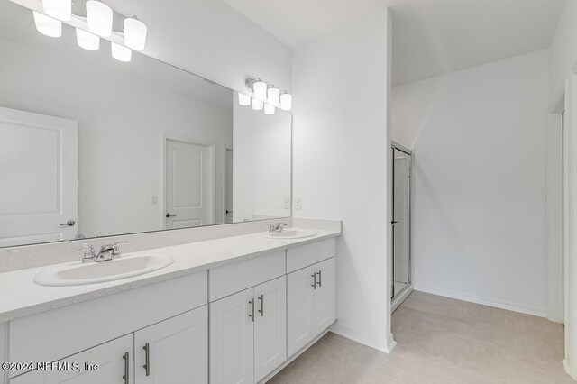 bathroom featuring vanity and an enclosed shower