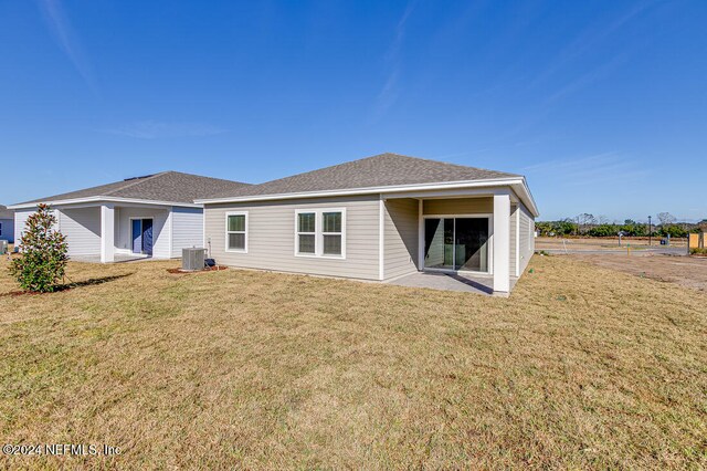 rear view of property featuring central AC and a yard