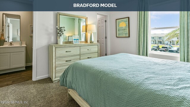 bedroom with dark colored carpet, a sink, ensuite bath, and baseboards