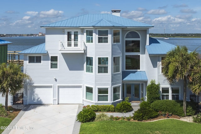 view of front of home with a balcony, a garage, and a water view