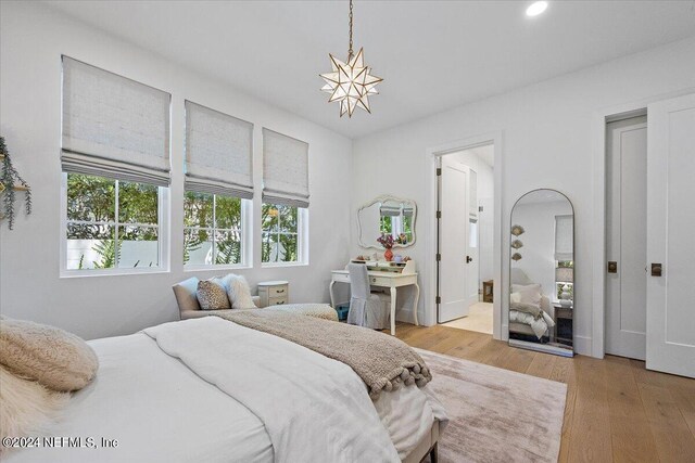 bedroom featuring light hardwood / wood-style flooring and ensuite bath