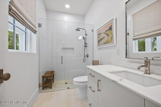 bathroom with tile patterned flooring, toilet, vanity, and walk in shower