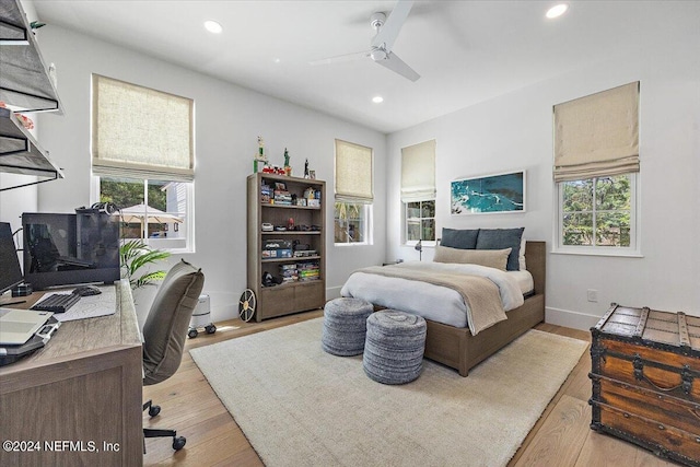 bedroom with multiple windows, light hardwood / wood-style flooring, and ceiling fan