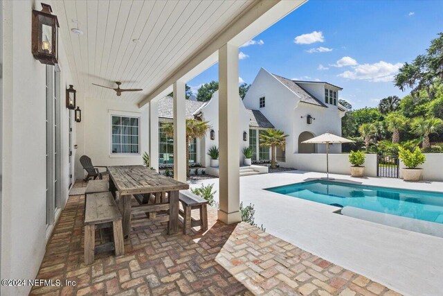 view of swimming pool featuring ceiling fan and a patio