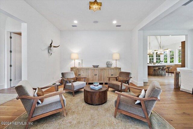 living room with hardwood / wood-style floors and an inviting chandelier